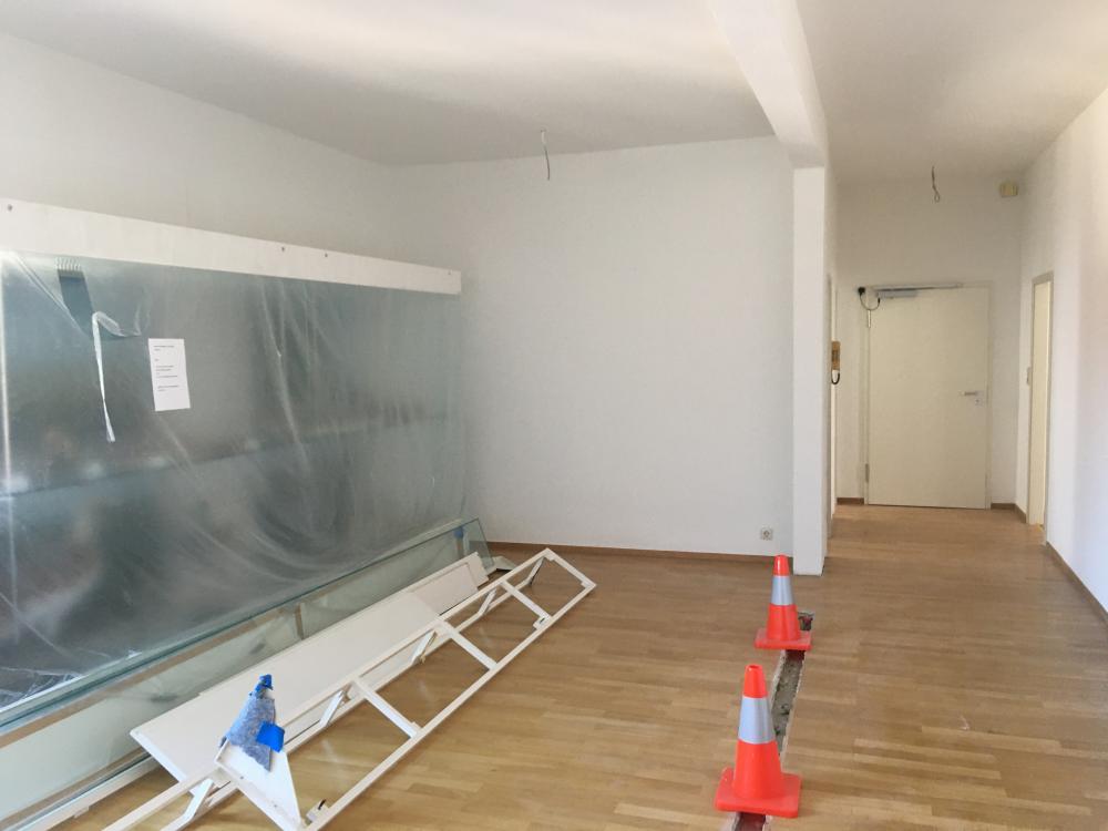 Der Gegenblick zeigt rechts  neben der großen Vitrine in  Raum 1 die für die Videoprojektion  vorgesehene Wand. Die auf dem  Boden liegenden lange Pultvitrine  wird in der Neugestaltung weiterverwendet.