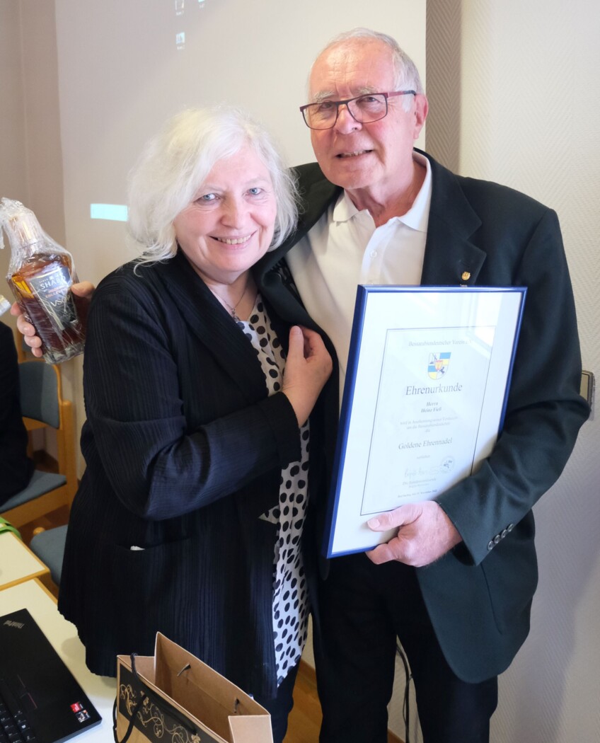 Brigitte Bornemann zeichnet Heinz Fieß mit  der Goldenen Ehrennadel des Bessarabiendeutschen Vereins aus. Überreichung der  Urkunde und einer Flasche Cognac aus  Schabo als Ehrengabe.