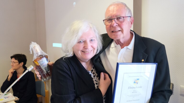 Brigitte Bornemann zeichnet Heinz Fieß mit  der Goldenen Ehrennadel des Bessarabiendeutschen Vereins aus. Überreichung der  Urkunde und einer Flasche Cognac aus  Schabo als Ehrengabe.