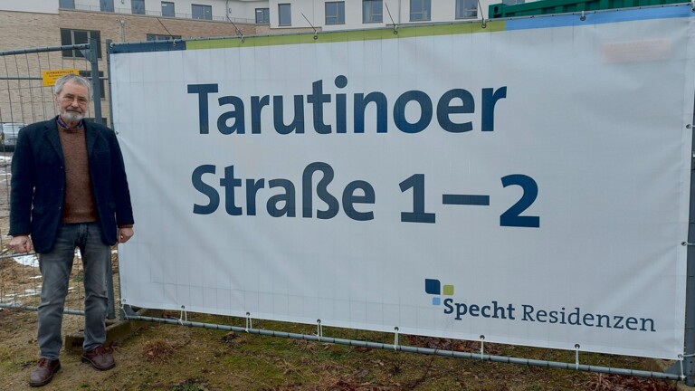 Armin Hinz am Plakat &bdquo;Tarutinoer Stra&szlig;e 1 - 2" an der Ecke Wulmstorfer Stra&szlig;e/ Tarutinoer Stra&szlig;e